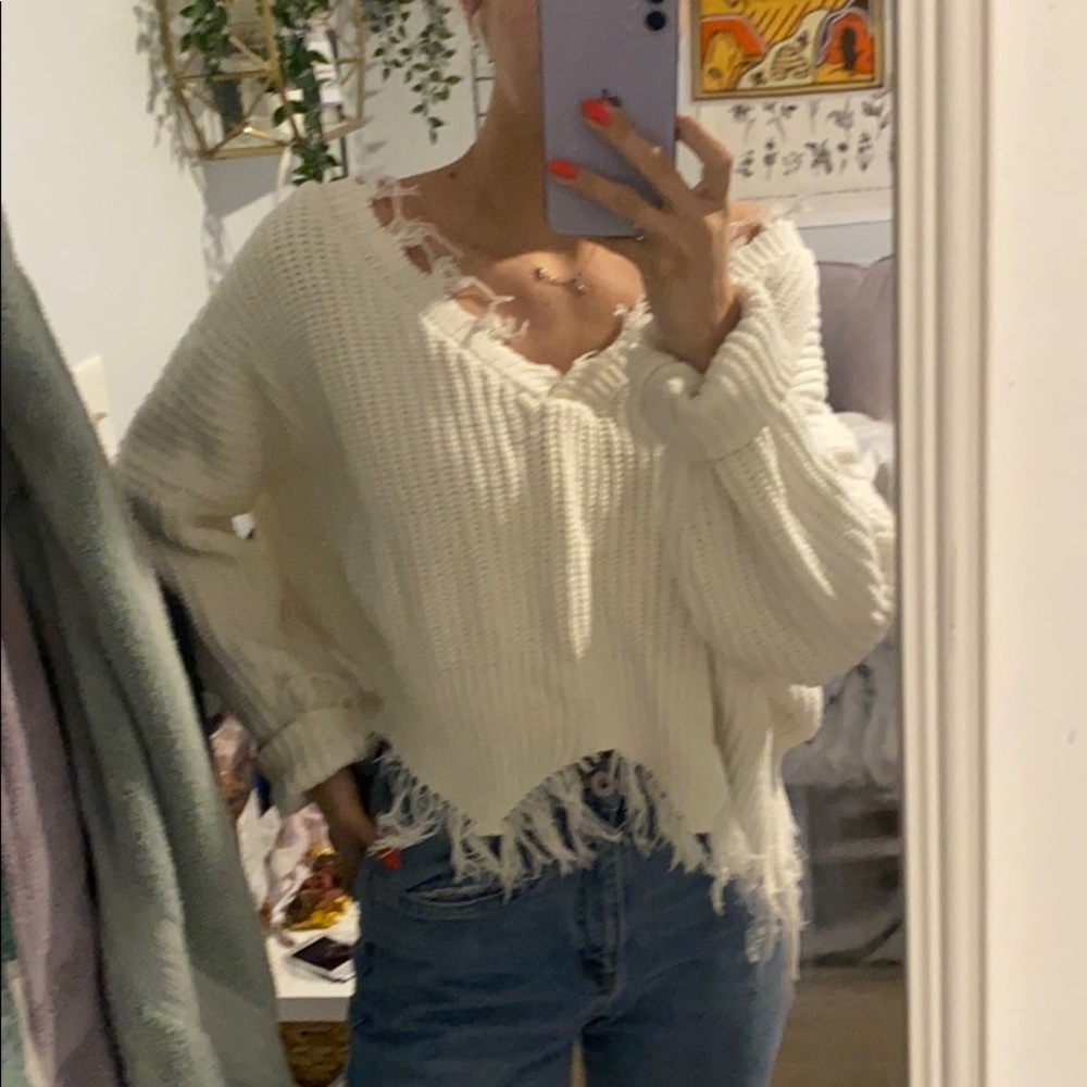 Oversized sweater with frayed edges.